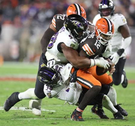 Cleveland Browns Shedeur Sanders (12) is sacked by Baltimore Ravens Travis Jones (98) and Keyon Martin (38)during the third quarter at Huntington Bank Field in Cleveland, Ohio on Sunday, November 16, 2025.  CLE20251116130 AARONxJOSEFCZYK