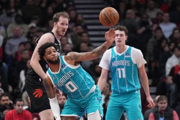 November 17, 2025, Toronto, On, CANADA: Charlotte Hornets forward Miles Bridges (0) controls the ball infront of Toronto Raptors center Jakob Poeltl (19) as Hornets center Ryan Kalkbrenner (11) looks on during first half NBA, Basketball Herren, USA basketball action in Toronto on Monday, November 17, 2025. Canada News - November 17, 2025  - ZUMAc35_ 20251117_zaf_c35_160 Copyright: xNathanxDenettex