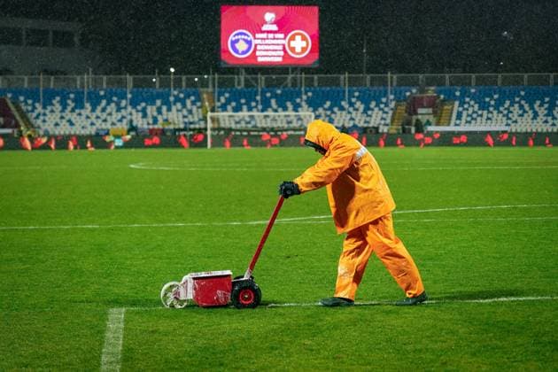 Football World Cup Qualification 2025 26, 10 Matchday Kosovo vs Switzerland Fadil Vokrri Stadium Pristina Pristina, Kosovo, Europe pitch workers in heavy rain, orange rain suit, line marking, soaked pitch, match preparation, weather chaos, floodlights, UEFA Quali, match operations, safety, infrastructure, groundskeeping, symbolic photo rain, media relevance severe weather, match conditions, soccer scenes Pristina Kosovo Copyright: xJOERANxSTEINSIEKx