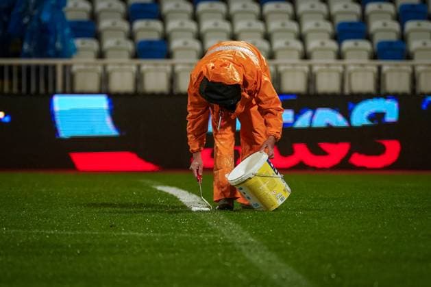 Football World Cup Qualification 2025 26, 10 matchday Kosovo vs Switzerland Fadil Vokrri Stadium Pristina Pristina, Kosovo, Europe pitch workers in heavy rain, manual line correction, bucket paint, rain protection orange, wet pitch, match preparation, infrastructure, groundskeeping, UEFA Quali, weather situation, safety, matchday, media relevance severe weather, pitch maintenance, soccer organization Pristina Kosovo Copyright: xJOERANxSTEINSIEKx