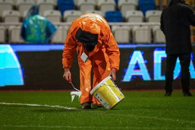 Football World Cup Qualification 2025 26, 10 matchday Kosovo vs Switzerland Fadil Vokrri Stadium Pristina Pristina, Kosovo, Europe pitch workers in heavy rain, manual line correction, bucket paint, rain protection orange, wet pitch, match preparation, infrastructure, groundskeeping, UEFA Quali, weather situation, safety, matchday, media relevance severe weather, pitch maintenance, soccer organization Pristina Kosovo Copyright: xJOERANxSTEINSIEKx