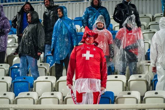 Football World Cup Qualification 2025 26, 10 Matchday Kosovo vs Switzerland Fadil Vokrri Stadium Pristina Pristina, Kosovo, Europe Swiss fans in heavy rain, dressed in red, supporter with painted face, scarves Switzerland Suisse SvizzerA Svizra, ponchos, fan block, emotions, away support, atmosphere, wetness, weather situation, qualification, soccer culture, media relevance fan behavior, weather, security, Matchday Pristina Kosovo Copyright: xJOERANxSTEINSIEKx
