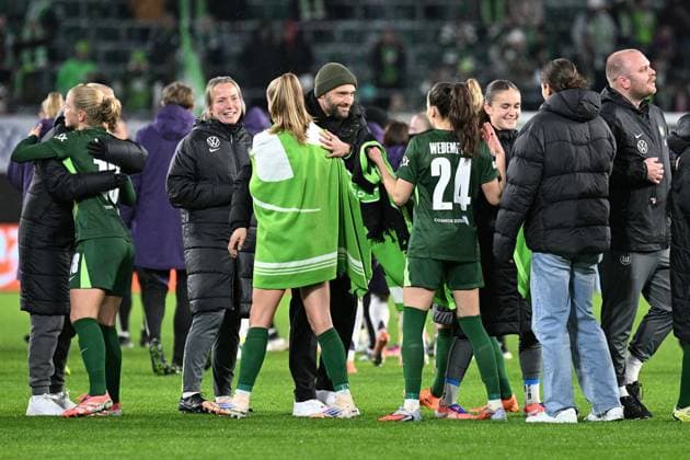 Soccer I Women I Season 2025 2026 I Champions League I Matchday 4 I VfL Wolfsburg Manchester United I 19 11 2025 Stephan Lerch Coach, VfL Wolfsburg center, with cap smiles and hugs goal scorer Vivien Endemann 25, VfL Wolfsburg with blanket Wolfsburg Volkswagen Arena Lower Saxony Germany Copyright: xLobeca InesxHähnelx