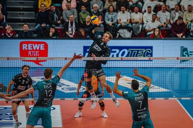 Volleyball Men Season 2025 2026 Volleyball Bundesliga Main Round SWD powervolleys Düren vs SVG Lüneburg 21 11 2025 Jackson Howe 6 SVG Lüneburg hits over the block of Siebe Korenblek 12 SWD powervolleys Düren and Jordan Canham 7 SWD powervolleys Düren