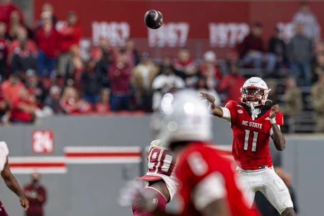 November 21, 2025, Raleigh, North Carolina, USA: NC State Wolfpack quarterback CJ BAILEY (11) scrambles and pass the ball on the move during the second half of the NCAA, College League, USA football game between the Florida State Seminoles and the NC State Wolfpack on November 21st, 2025 at Carter-Finley Stadium in Raleigh, NC. Raleigh USA - ZUMAa220 20251121_znp_a220_075 Copyright: xIsraelxAntax