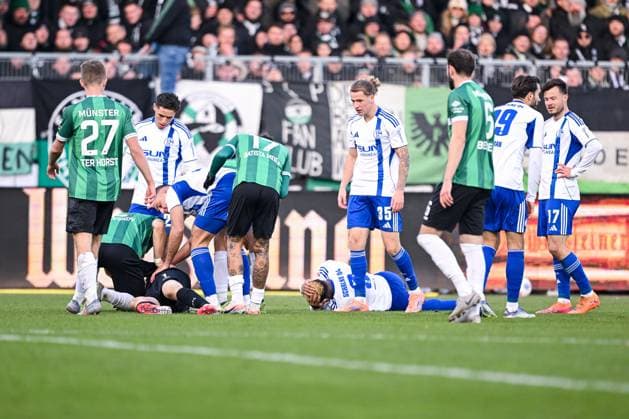 22 11 2025, Football, 2 Bundesliga, Season 2025 2026, Matchday 13, Preußen Münster FC Schalke 04, Johannes Schenk Preußen Münster is on the ground and Nikola Katic FC Schalke 04 puts him in the recovery position, xRHR PHOTO YYx Copyright: KROEGER RHR-FOTOx RHR-FOTO YY