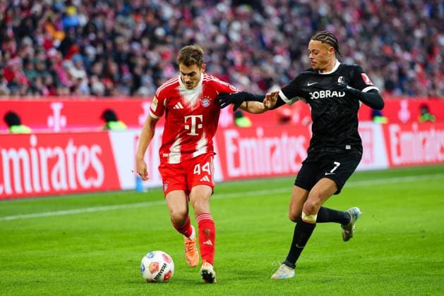 Josip Stanisic 44, FC Bayern München and Derry Scherhant 7, SC Freiburg at the match between FC Bayern München v SC Freiburg, Football, Men, Bundesliga, 2025 2026, Matchday 11 on 22 11 2025 in Munich, Allianz Arena DFL and DFB regulations prohibit any use of photographs as image sequences and or quasi video Bayern Germany