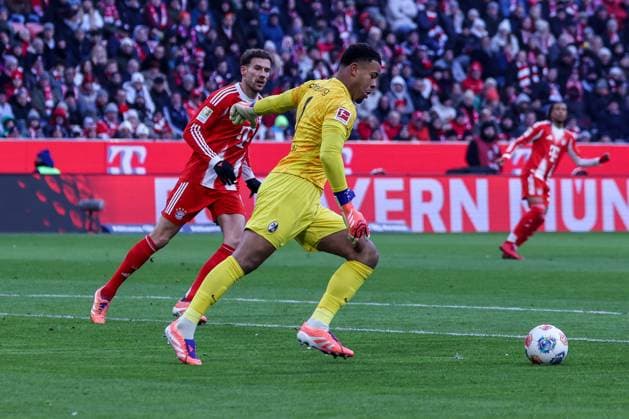 Noah Atubolu 1 SC Freiburg with a tee shot, in front of Leon Goretzka 8 FC Bayern Muenchen , FC Bayern Muenchen vs SC Freiburg, Football, Bundesliga, DFL, Saison 2025 2026, Hinrunde, 22 11 2025 DFB regulations prohibit any use of photographs as image sequences and or quasi video Muenchen Bayern Germany Copyright: xkolbert-press MartinxAgüerax