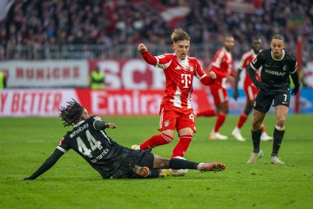 Karl Lennart 42 FC Bayern Muenchen in duel with Johan Manzambi 44 SC Freiburg , FC Bayern Muenchen SC Freiburg, Soccer, Bundesliga, 11 Matchday, 22 11 2025 DFB regulations prohibit any use of photographs as image sequences and or quasi video Muenchen Bayern Germany Copyright: xkolbert-press UlrichxGamelx