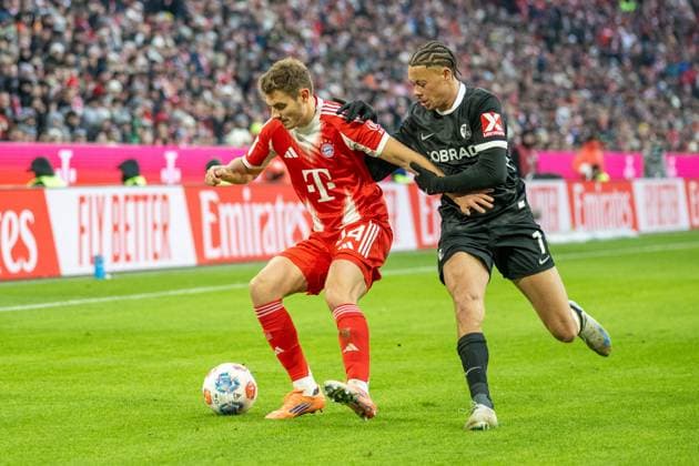 Josip Stanisic 44 FC Bayern Muenchen in duel with Derry Scherhant 7 SC Freiburg , FC Bayern Muenchen SC Freiburg, Football, Bundesliga, 11 Matchday, 22 11 2025 DFB regulations prohibit any use of photographs as image sequences and or quasi video Muenchen Bayern Germany Copyright: xkolbert-press UlrichxGamelx