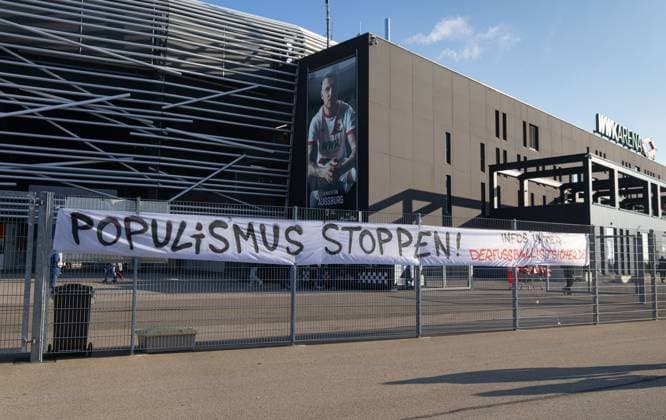 Protest poster on the fence in front of the WWK Arena Stop populism FC Augsburg vs Hamburger SV, matchday 11 DFL REGULATIONS PROHIBIT ANY USE OF PHOTOGRAPHS AS IMAGE SEQUENCES AND OR QUASI VIDEO