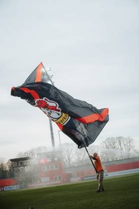 22 11 25, Women, Football, Google Pixel Womens Bundesliga, Season 2025 2026, Bayer 04 Leverkusen SGS Essen, Matchday 11 A Leverkusen fan volunteer waves a large flag on the pitch Leverkusen Ulrich Haberland Stadium NRW Germany