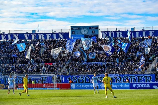 Fans of TSV 1860 Muenchen waving flags and making atmosphere, Fans, Audience, Spectators, Atmosphaere, Stadium, 23 11 2025, Munich Germany , Football, 3 Liga, TSV 1860 München 1 FC Saarbrücken, DFB DFL REGULATIONS PROHIBIT ANY USE OF PHOTOGRAPHS AS IMAGE SEQUENCES AND OR QUASI VIDEO xslx