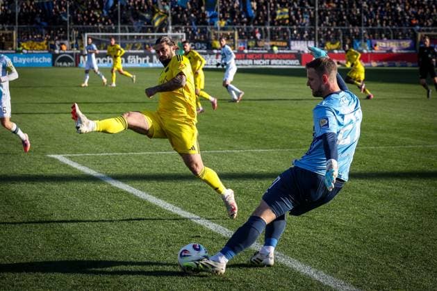 Thomas Daehne 21 TSV 1860 Muenchen with a drive that Dominic Baumann 30 1 FC Saarbruecken blocks, TSV 1860 Muenchen vs 1 FC Saarbruecken, Football, Third League, DFL, Season 2025 2026, Hinrunde, 15 Spieltag, 23 11 2025 DFB regulations prohibit any use of photographs as image sequences and or quasi video Muenchen Bayern Germany Copyright: xkolbert-press MartinxAgüerax