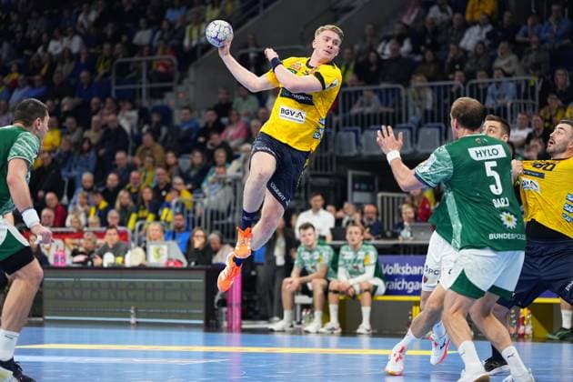 Haukur Thrastarson 25 Rhein Neckar Löwen throws on goal, while Max Darj 5 Füchse Berlin defends and Jannik Kohlbacher 80 Rhein Neckar Löwen is positioned at the back 1 Handball Bundesliga Rhein Neckar Löwen vs Füchse Berlin 23 11 2025 Copyright: xSpeedshotx