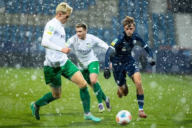 23 11 2025, xkwix, Football, Regionalliga West, VfL Bochum 1848 U21 FC Gütersloh, Vonovia Ruhrstadion Luis Frieling FC Gütersloh 21 in duel against Kacper Koscierski VfL Bochum U21 2 in the snow NRW Germany
