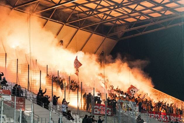 3 Liga Rot Weiss Essen FC Energie Cottbus 23 11 2025 Numerous Bengalo, Pyro 3 Liga Rot Weiss Essen FC Energie Cottbus, Essen, Stadion an der Hafenstrasse on 23 11 2025 DFB REGULATIONS PROHIBIT ANY USE OF PHOTOGRAPHS AS IMAGE SEQUENCES AND OR QUASI VIDEO in the guest block of FC Energie Cottbus fans at the end of the 12 minutes of silence Copyright: xBEAUTIFULxSPORTS Wunderlx