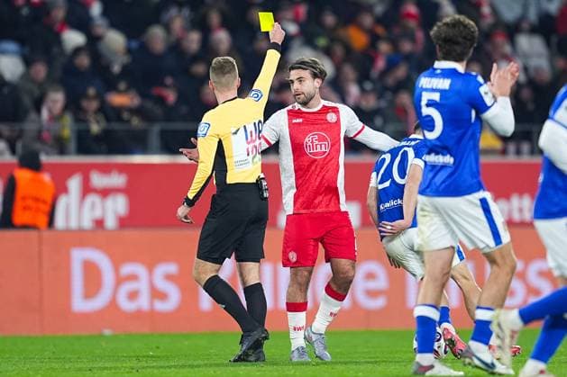 23 11 2025, xydrx, Football, 3 Liga, Rot Weiss Essen FC Energie Cottbus, Season 2025 2026, Stadion an der Hafenstraße Martin Wilke Referee shows Jose Enrique Rios Alonso Rot Weiss Essen 23 the yellow card DFB regulations prohibit any use of photographs as image sequences and or quasi video Nordrhein Westfahlen Germany