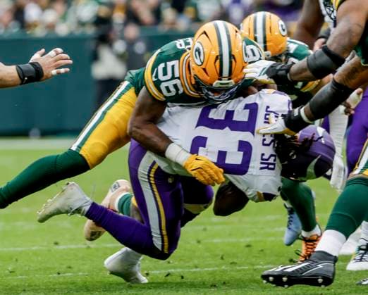 Minnesota Vikings running back Aaron Jones Sr. (Bottom) is taken down by Green Bay Packers linebacker Edgerrin Cooper (Top) in the first half of the NFL, American Football Herren, USA game between the Minnesota Vikings and the Green Bay Packers at Lambeau Field in Green Bay, Wisconsin on Monday, November 23, 2025.  MIL20251123818 TANNENxMAURY