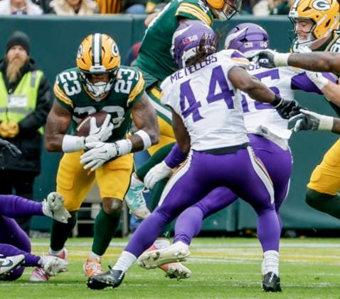 Green Bay Packers running back Emanuel Wilson (L) runs the ball on Minnesota Vikings safety Joshua Metellus (R) in the first half of the NFL, American Football Herren, USA game between the Minnesota Vikings and the Green Bay Packers at Lambeau Field in Green Bay, Wisconsin on Monday, November 23, 2025.  MIL20251123813 TANNENxMAURY