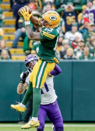 Green Bay Packers wide receiver Dontayvion Wicks (Front) catches a pass in front of Minnesota Vikings linebacker Blake Cashman (Rear) in the first half of the NFL, American Football Herren, USA game between the Minnesota Vikings and the Green Bay Packers at Lambeau Field in Green Bay, Wisconsin on Monday, November 23, 2025.  MIL20251123814 TANNENxMAURY