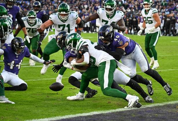 New York Jets running back Breece Hall (20) fumbles under pressure from Baltimore Ravens cornerback Marlon Humphrey (44) who recovered the ball on the 3 yard line for a turnover during the fourth quarter at M&T Bank Stadium in Baltimore, Maryland, on Sunday, November 23, 2025. Baltimore won 23-10.  BAL20251123126127 DAVIDxTULIS