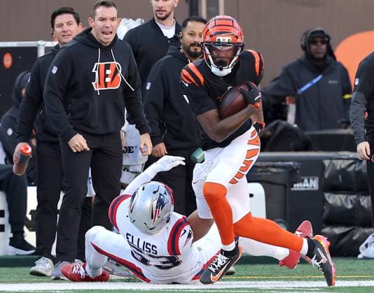 Cincinnati Bengals wide receiver Tee Higgins (5) is dragged out of bounds by New England Patriots Christian Elliss (53) during the first half of play at Paycor Stadium on Sunday, November 23, 2025 in Cincinnati, Ohio.  KYP20251123027 JOHNxSOMMERSxII