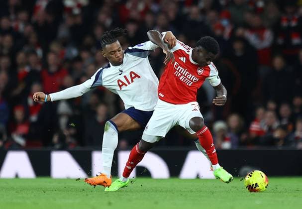 Destiny Udogie of Tottenham Hotspur competes for the ball with Bukayo Saka of Arsenal Arsenal v Tottenham Hotspur, Premier League, Football, Emirates Stadium, London, UK - 23 Nov 2025London Emirates Stadium United Kingdom EDITORIAL USE ONLY No use with unauthorised audio, video, data, fixture lists, club league logos or live services. Online in-match use limited to 120 images, no video emulation. No use in betting, games or single club league player publications.  Copyright: xMichaelxZemanek Shutterstockx 15860967cz