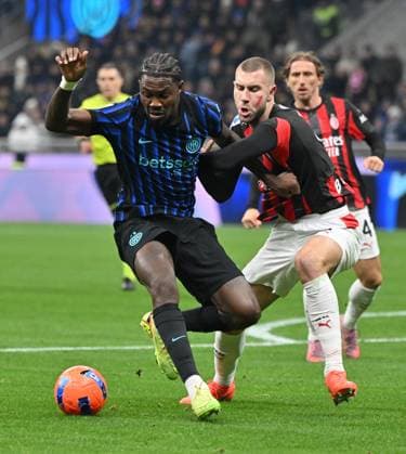 (251124) -- MILAN, Nov. 24, 2025 -- Inter Milan s Marcus Thuram (L) vies with AC Milan s Strahinja Pavlovic during a Serie A football match between Inter Milan and AC Milan in Milan, Italy, Nov. 23, 2025. (Photo by Xinhua) (SP)ITALY-MILAN-FOOTBALL-SERIE A-INTER MILAN VS AC MILAN AlbertoxLingria 