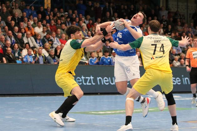 24 11 2025 Handball Men 2025 2026 2 Bundesliga 12 Matchday Dessau Roßlauer HV 06 VfL Eintracht Hagen Anhalt Arena Dessau Marcel Nowak DRHV, blue is illegally stopped by Tilman Pröhl Hagen, yellow, left Josip Jukic Hagen, yellow looks on Dessau Roßlau Saxony Anhalt Germany