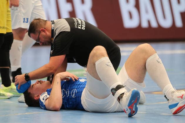 24 11 2025 Handball Men 2025 2026 2 Bundesliga 12 Matchday Dessau Roßlauer HV 06 VfL Eintracht Hagen Anhalt Arena Dessau Marcel Nowak DRHV, blue is treated by Ive Lassanske DRHV, Physio after a foul Dessau Roßlau Saxony Anhalt Germany