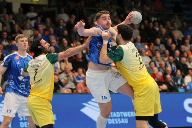 24 11 2025 Handball Men 2025 2026 2 Bundesliga 12 Matchday Dessau Roßlauer HV 06 VfL Eintracht Hagen Anhalt Arena Dessau Marcel Nowak DRHV, blue rises to throw and is prevented from doing so by Pouya Norouzinezhad Hagen, yellow, left and Philip Jungemann Hagen, yellow, right Dessau Roßlau Saxony Anhalt Germany