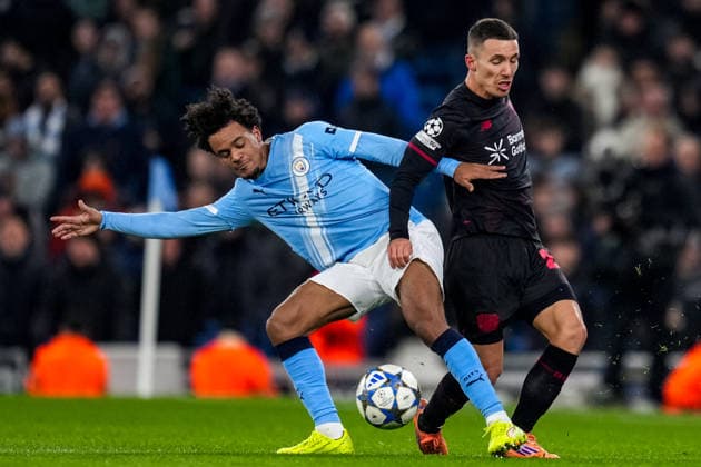 MANCHESTER, ENGLAND - NOVEMBER 25: Oscar Bobb of Manchester City and Alejandro Grimaldo of Bayer 04 Leverkusen battle for the ball during the UEFA Champions League 2025 26 League Phase MD5 match between Manchester City and Bayer 04 Leverkusen at City of Manchester Stadium on November 25, 2025 in Manchester, England. (Photo by Rene Nijhuis) SPO  Copyright: xRenexNijhuis