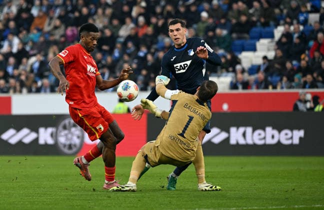 29 11 2025, xjhx, Soccer 1 Bundesliga, TSG 1899 Hoffenheim FC Augsburg v l Samuel Essende FC Augsburg , Oliver Baumann 1899 Hoffenheim , Robert Hranac 1899 Hoffenheim DFL DFB REGULATIONS PROHIBIT ANY USE OF PHOTOGRAPHS as IMAGE SEQUENCES and or QUASI VIDEO Sinsheim
