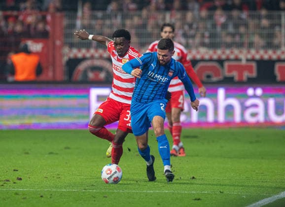 Soccer, Men, Season 2025 2026, 1 Bundesliga 12 Matchday , 1 FC Union Berlin 1 FC Heidenheim, v l Derrick Köhn 1 FC Union Berlin , Marnon Busch Heidenheim , 29 11 2025, Copyright: xSebastianxRäppold MatthiasxKochx