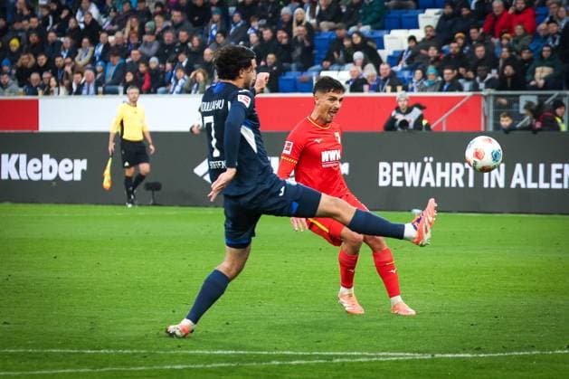 Dimitris Giannoulis 13 FC Augsburg attempts a lob that misses the goal, with Leon Avdullahu 7 TSG 1899 Hoffenheim , TSG Hoffenheim vs FC Augsburg, Football, Bundesliga, DFL, 2025 2026 season, Hinrunde, 12 Spieltag, 29 11 2025 DFB regulations prohibit any use of photographs as image sequences and or quasi video Sinsheim Baden Wuerttemberg Germany Copyright: xkolbert-press MartinxAgüerax