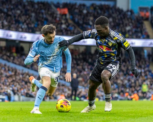 29th November 2025; Etihad Stadium, Manchester, Lancashire, England; Premier League Football, Manchester City versus Leeds United; Bernardo Silva of Manchester City under pressure from Wilfried Gnonto of Leeds United  TimxWilliams