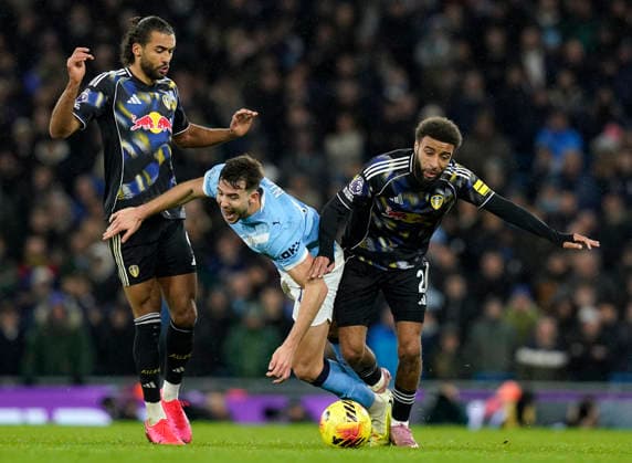 Manchester, England, 29th November 2025. Nico Gonzalez of Manchester City (C) is challenged by Jayden Bogle of Leeds United (R) and Dominic Calvert-Lewin of Leeds United during the Manchester City vs Leeds United Premier League match at the Etihad Stadium, Manchester. Picture credit should read: Andrew Yates Sportimage EDITORIAL USE ONLY. No use with unauthorised audio, video, data, fixture lists, club league logos or live services. Online in-match use limited to 120 images, no video emulation. No use in betting, games or single club league player publications. SPI_033_AY_MAN_CITY_LEEDS SPI-4333-0033