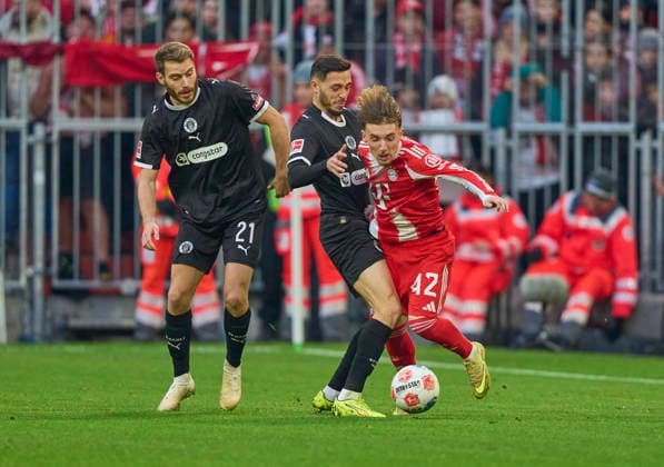 Lennart Karl of FC Bayern München compete for the ball, tackling, duel, header, zweikampf, action, fight against Mathias Pereira Lage of St.Pauli Lars Ritzka of St.Pauli in the match FC BAYERN MÜNCHEN - FC ST. PAULI 3-1 on November 29, 2025 at Allianz Arena München, Germany. Season 2026 2026, 1.Bundesliga, FCB, matchday 12,