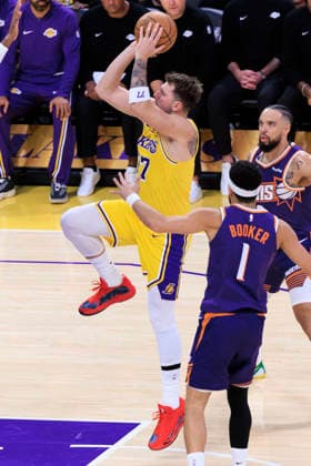 December 1, 2025, Los Angeles, California, USA: Luka Doncic 77 of the Los Angeles Lakers shoots a floater as Devin Booker 1 and Dillon Brooks 3 of the Phoenix Suns t defend during their regular season NBA, Basketball Herren, USA game on Monday December 1, 2025 at Crypto.com Arena in Los Angeles, California. ARIANA RUIZ PI Los Angeles USA - ZUMAp124 20251201_zaa_p124_013 Copyright: xArianaxRuizx