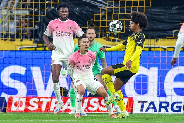 02 12 2025, Football, DFB Cup, Borussia Dortmund Bayer 04 Leverkusen, Round of 16, Signal Iduna Park, Season 2025 2026 Karim Adeyemi BVB 27 in duel against Alejandro Grimaldo Bayer04 20 in front of goalkeeper Mark Flekken Bayer04 01 DFB regulations prohibit any use of photographs as image sequences and or quasi video Nordrhein Westfalen Germany