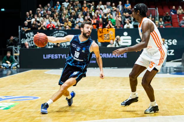 04 12 2025, xomx, Basketball EuroCup, Niners Chemnitz Turk Telekom v l DOGUS OZDEMIROGLU Turk Telekom Ankara on the ball in a duel with Tyron Brewer Niners Chemnitz Chemnitz
