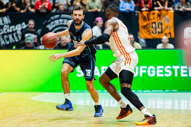 04 12 2025, xomx, Basketball EuroCup, Niners Chemnitz Turk Telekom v l DOGUS OZDEMIROGLU Turk Telekom Ankara on the ball in a duel with John Newman III Niners Chemnitz Chemnitz