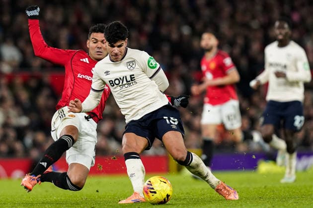Manchester, England, 4th December 2025. Mateus Fernandes of West Ham United passes the ball whilst getting pressured by Casemiro of Manchester United, ManU during the Manchester United vs West Ham United Premier League match at Old Trafford, Manchester. Picture credit should read: Andrew Yates Sportimage EDITORIAL USE ONLY. No use with unauthorised audio, video, data, fixture lists, club league logos or live services. Online in-match use limited to 120 images, no video emulation. No use in betting, games or single club league player publications. SPI_049_AY_MANUTD_WESTHAM SPI-4345-0050