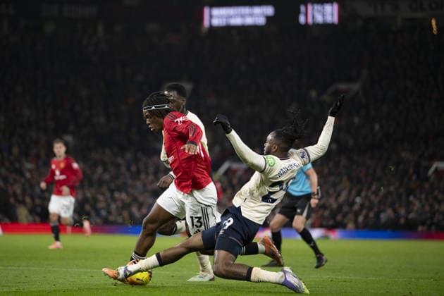 MANCHESTER, ENGLAND, DEC 04: Aaron Wan-Bissaka of West Ham and Patrick Dorgu of Manchester United, ManU fight for possession during the Premier League match between Manchester United and West Ham United on December 04, 2025 in Manchester, England. Copyright: xWillxPalmer SportsxPressxPhotox Sportspressphoto_SPR69880