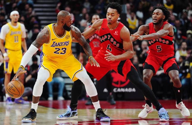 December 4, 2025, Toronto, On, Canada: Los Angeles Lakers LeBron James (23) protects the ball from Toronto Raptors Scottie Barnes (4) and Immanuel Quickley (5) during first half NBA, Basketball Herren, USA basketball action in Toronto on Thursday, Dec. 4, 2025. Canada News - December 4, 2025  - ZUMAc35_ 20251204_zaf_c35_164 Copyright: xFrankxGunnx