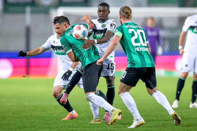 05 12 2025, Football, Preußen Münster Hannover 96, 2 Fußball Bundesliga, Preußenstadion, Saison 2025 2026 Noel Aseko Hannover96 15 in duel against Yassine Bouchama Preussen Muenster 05 and Jorrit Hendrix Preussen Muenster 20 DFB regulations prohibit any use of photographs as image sequences and or quasi video Nordrhein Westfalen Germany