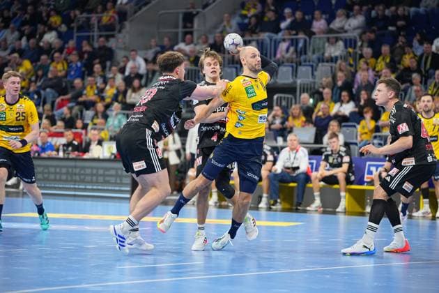 Lukas Sandell 11 Rhein Neckar Löwen with ball while Stephan Seitz 44 HC Erlangen defends and Haukur Thrastarson 25 Rhein Neckar Löwen supports Handball scene with Lukas Sandell 11 Rhein Neckar Löwen , Stephan Seitz 44 HC Erlangen and Haukur Thrastarson 25 Rhein Neckar Löwen Copyright: xspeedshotx