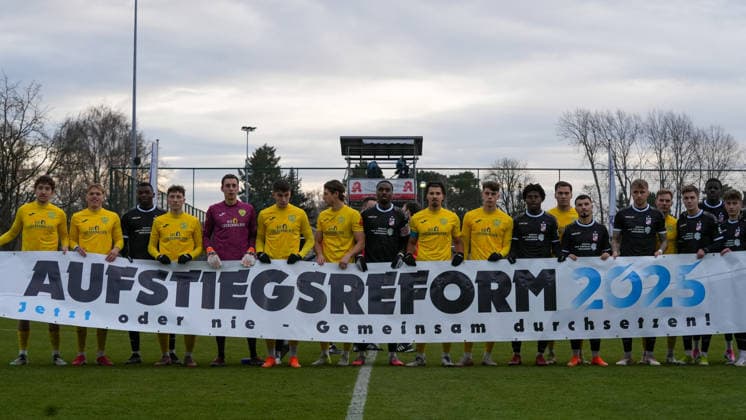 Fußball, Herren, Saison 2025 2026, Regionalliga Nordost, 18. Spieltag, FSV 63 Luckenwalde vs. FC Rot-Weiß Erfurt, Samstag 06.12.2025, Werner-Seelenbinder-Stadion Luckenwalde, Im Bild: Beide Mannschaften halten ein Banner zur Aufstiegsreform 2025 Brandenburg Deutschland *** Soccer, Men, Season 2025 2026, Regionalliga Nordost, Matchday 18, FSV 63 Luckenwalde vs FC Rot Weiß Erfurt, Saturday 06 12 2025, Werner Seelenbinder Stadion Luckenwalde, In the picture both teams hold a banner for the promotion reform 2025 Brandenburg Germany