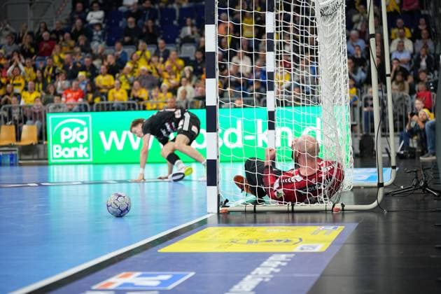 Mike Jensen 20 Rhein Neckar Löwen lies in goal while Klemen Ferlin 22 HC Erlangen supports himself on the court Handball scene with Mike Jensen 20 Rhein Neckar Löwen and Klemen Ferlin 22 HC Erlangen Copyright: xspeedshotx